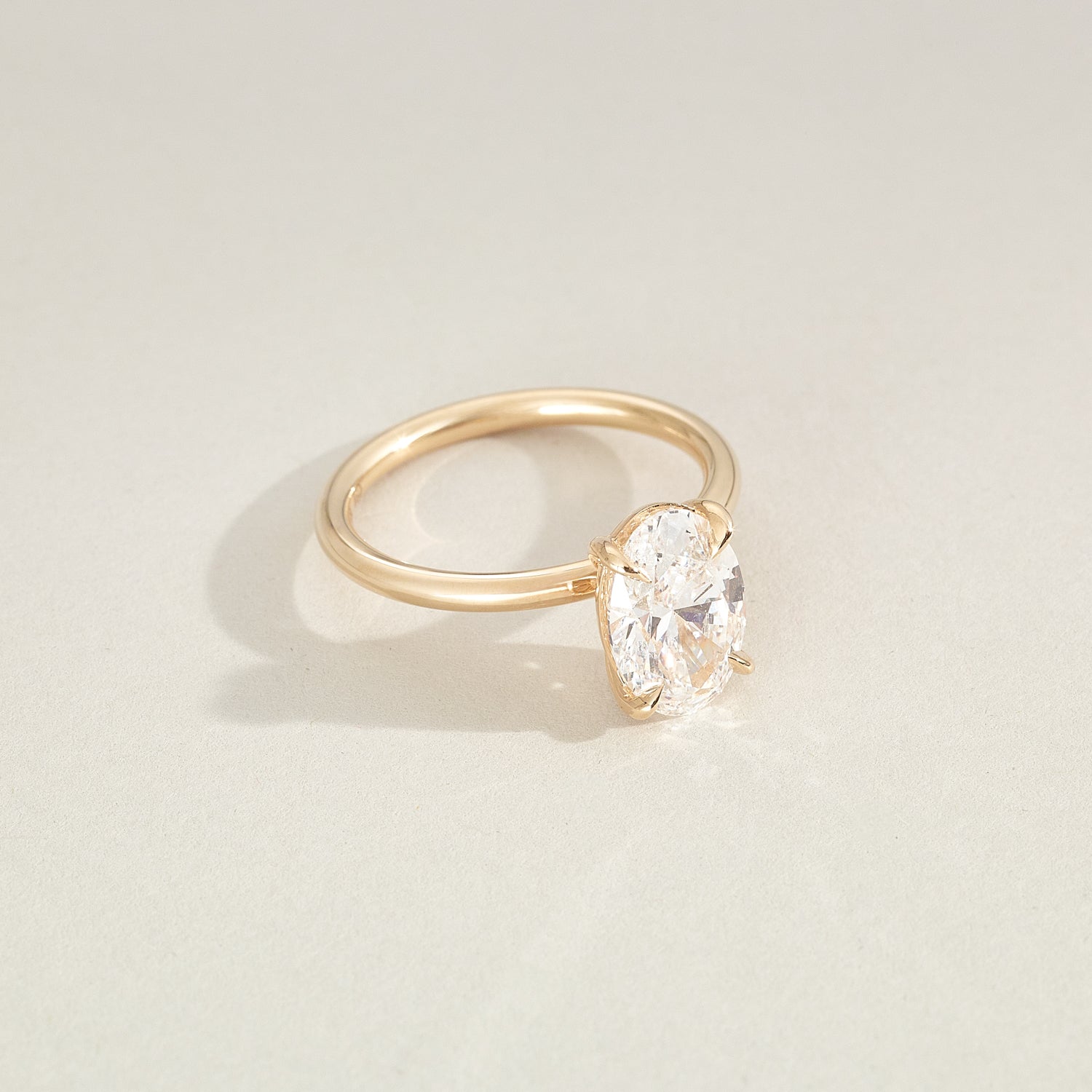 Gold ring with a diamond on a light beige background