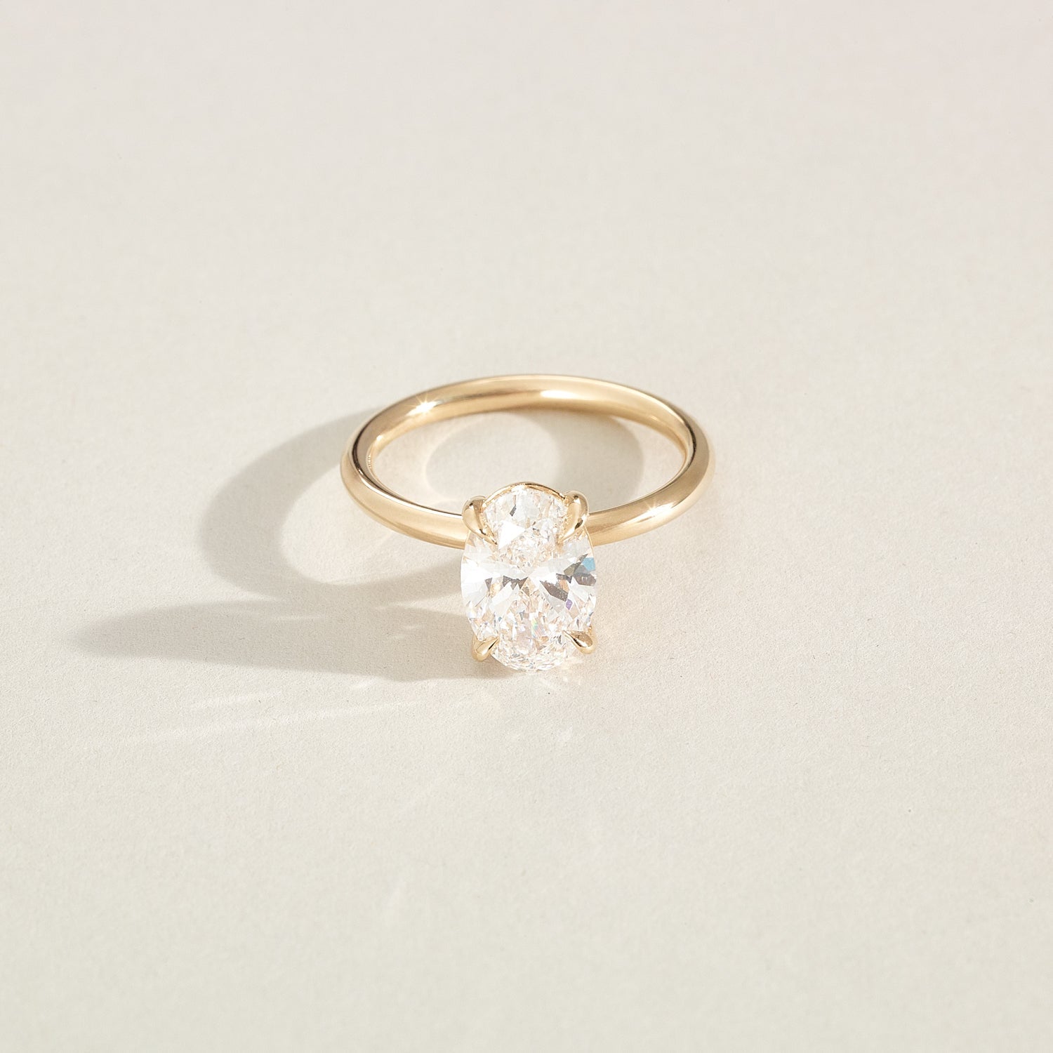 Gold ring with a diamond on a light beige background