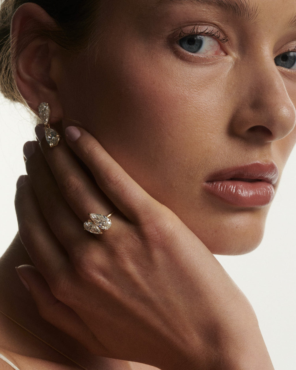 Close-up of a woman wearing diamond earrings with a neutral background
[text overlay: Andrea wears the Nouve Duet paired with the Nouve Drops]