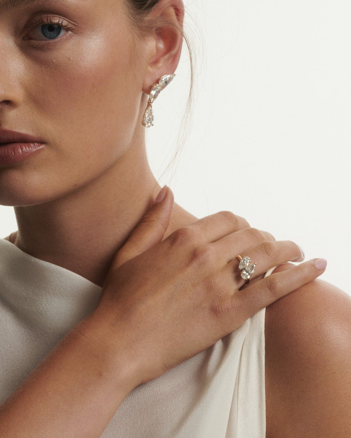 Close-up of a woman wearing a diamond ring and earrings on a neutral background
[text overlay: Andrea wears the Nouve Duet paired with the Nouve Drops and Studs]