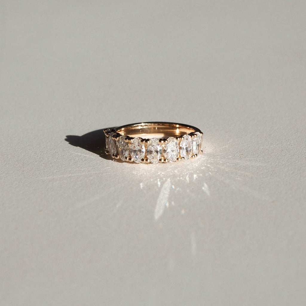 A half-infinity style ring, featuring an array of oval lab-grown diamonds that end and begin again — replicating the circular journey of true love. This piece is created with eight 5x3mm lab-grown oval cut diamonds, splayed along a round gold band. The total carat weight is approximately 1.60ct.