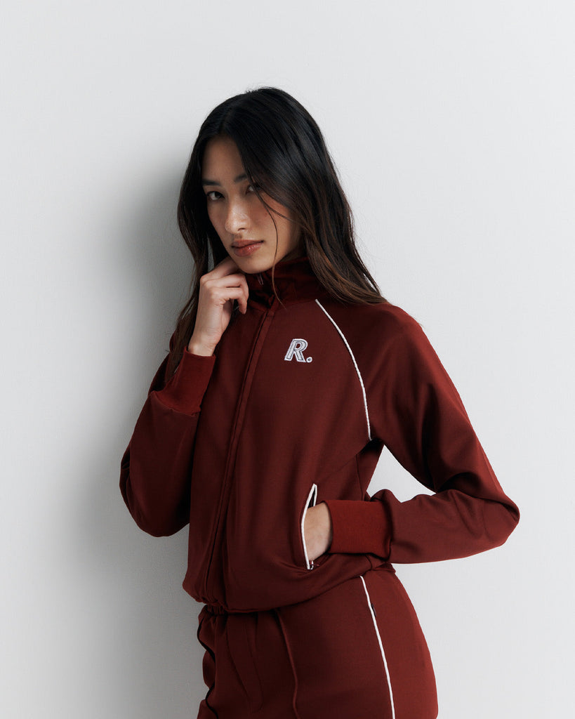 The RAS Sweater is a sports-inspired zip-front jacket featuring a high neck, contrast piping, and a slim fit. Designed with side zip pockets, chunky ribbed cuffs and hem, and finished with our signature Romy Athletic Society 'R' embroidery at the front.