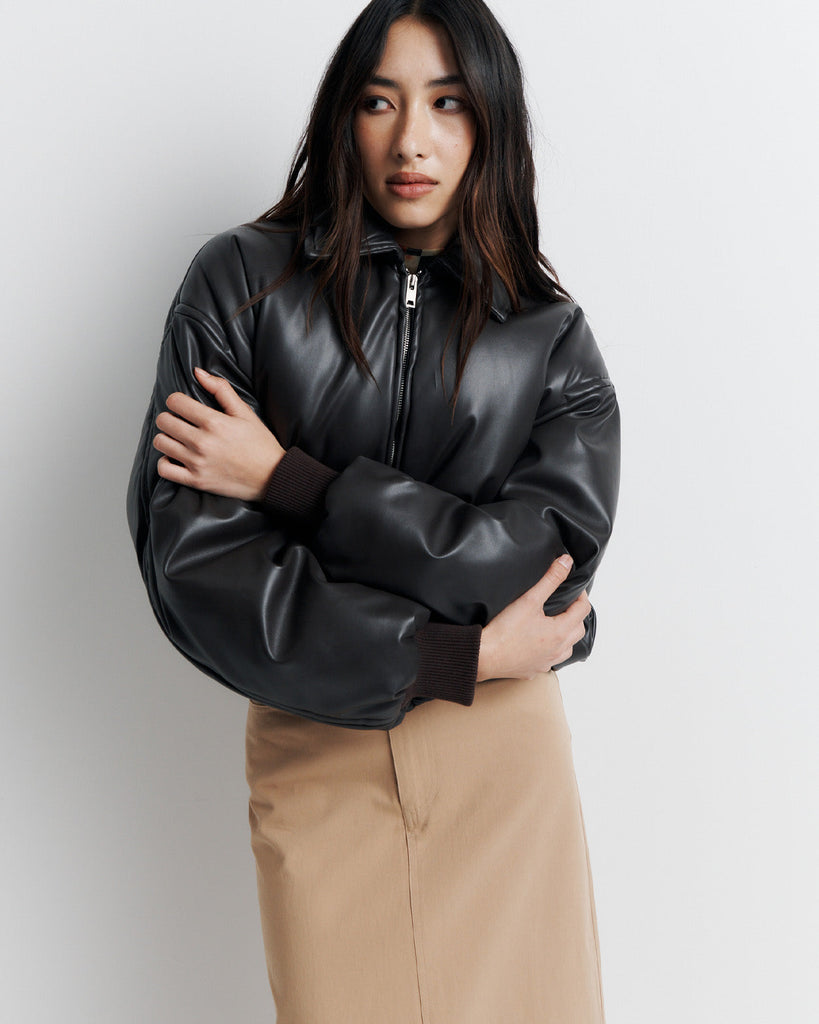 Stay warm and stylish in our chocolate brown, vegan leather Padded Bomber Jacket. Crafted with a super soft feel, gathered hem, and ribbed knit cuffs... it's a must-have. Shop now!