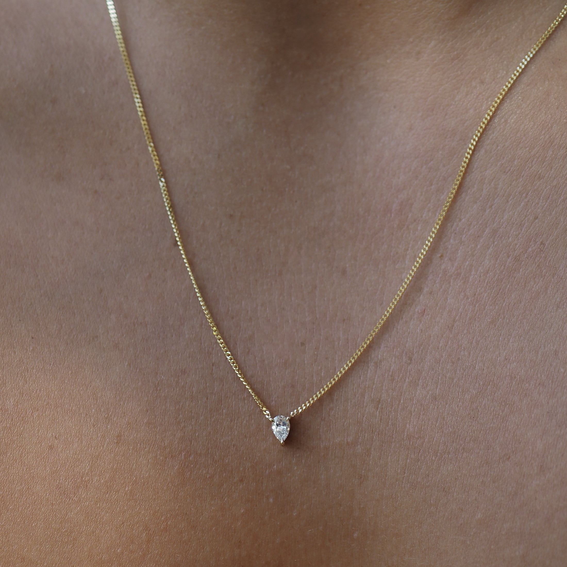 The Pear Diamond Necklace features a stunning lab-grown diamond handset within three claws, fixed along a yellow gold chain.